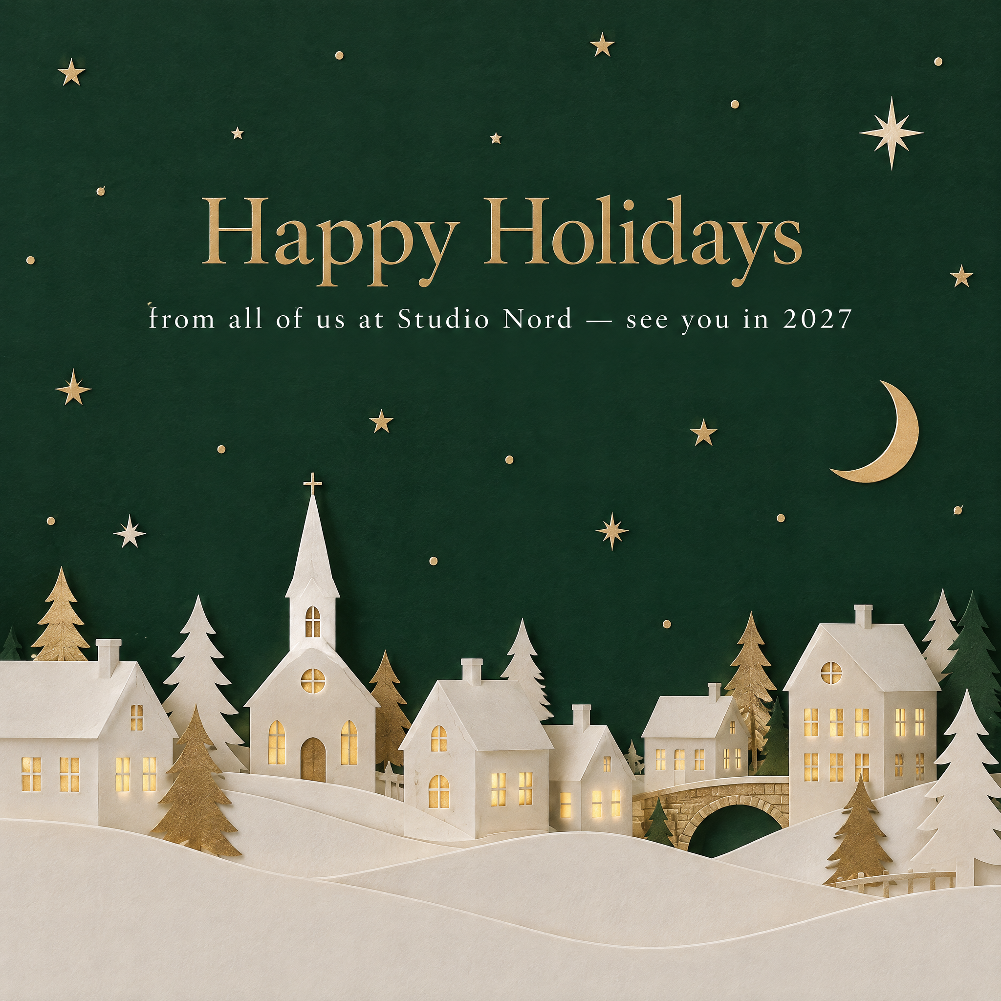 Paper-cut village holiday card in white and gold on pine green
